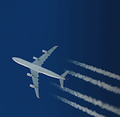High-altitude cargo airplane flying across a clear sky with contrails, symbolizing fast and reliable global air freight logistics and time-critical cargo transport solutions.