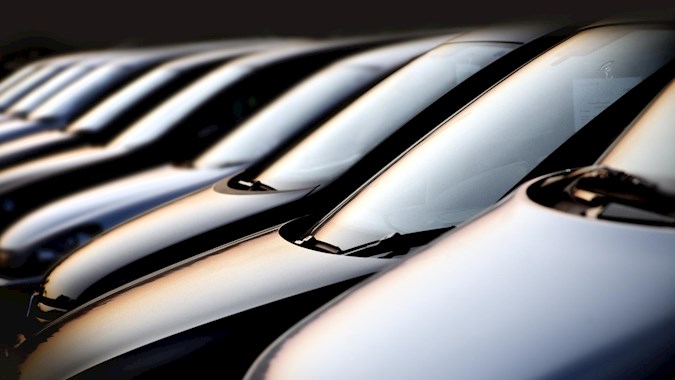 Modern automotive assembly line with vehicles and technicians, showcasing integrated logistics for efficient and scalable car production.