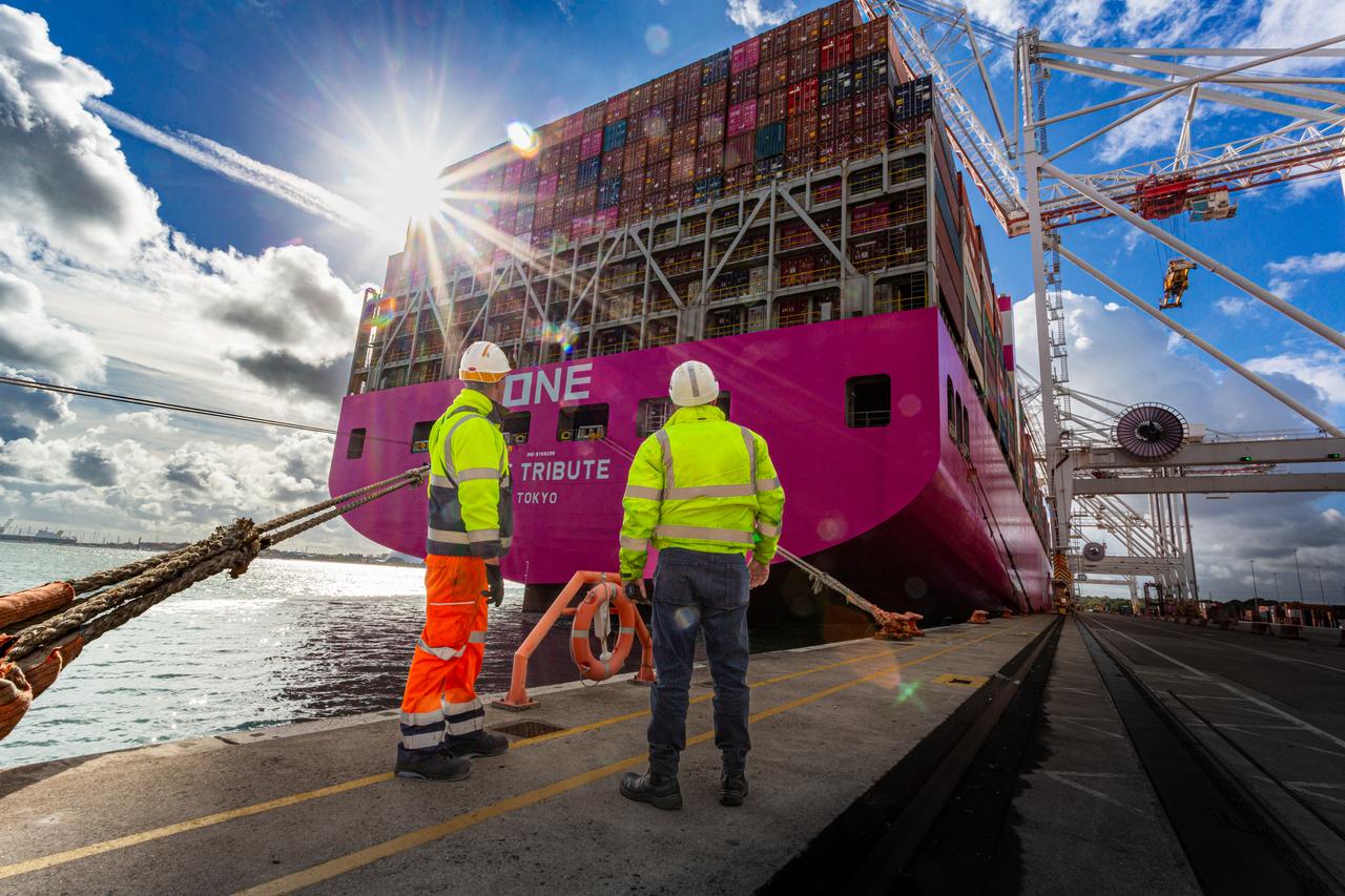 Port workers waiting for the arrival of a container ship on the dock at Southampton Terminal UK